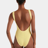 Yellow swimsuit with open back worn by a model on a white background