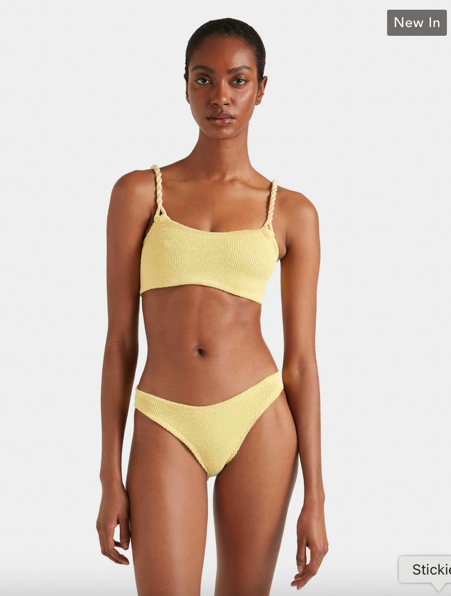 Woman wearing a yellow bikini set on a white background