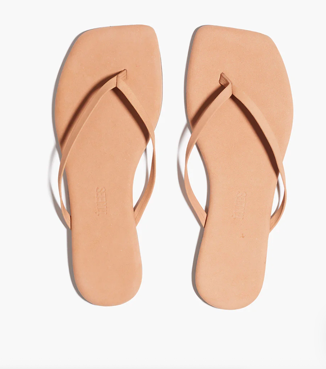 Pair of beige flip-flops on a white background
