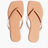 Pair of beige flip-flops on a white background