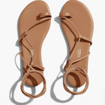Pair of tan sandals with 'TKEES' branding on a white background