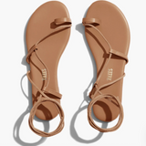 Pair of tan sandals with 'TKEES' branding on a white background