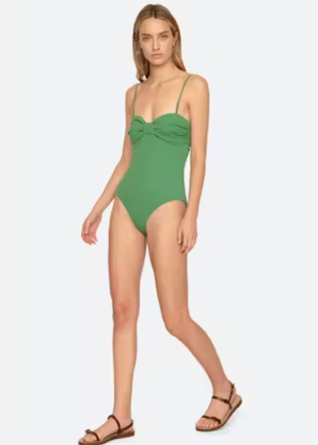 Woman wearing a green swimsuit on a white background