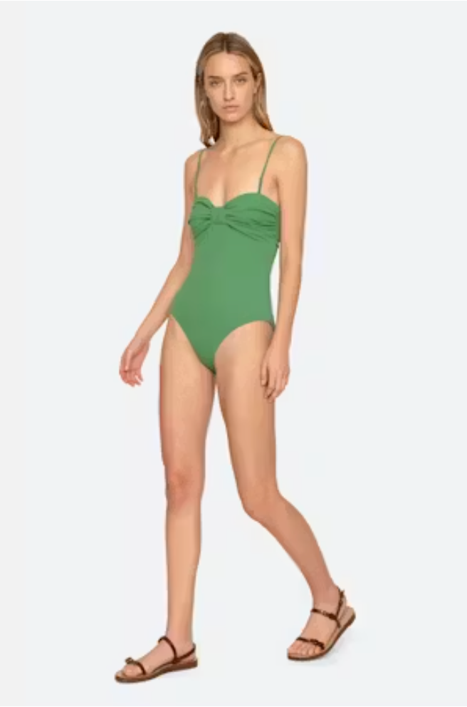 Woman wearing a green swimsuit on a white background