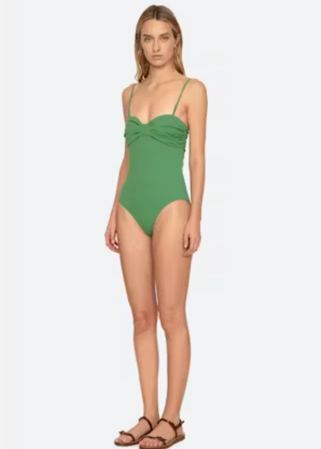Woman wearing a green swimsuit on a white background