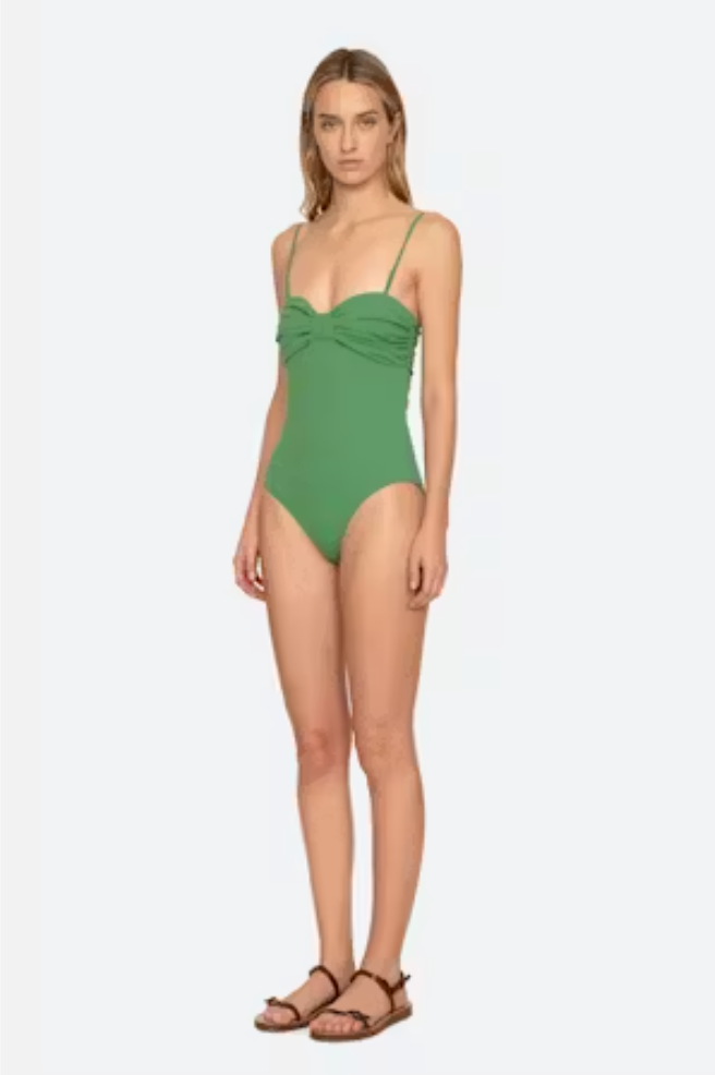Woman wearing a green swimsuit on a white background
