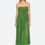 Woman wearing a green strapless lace dress on a white background