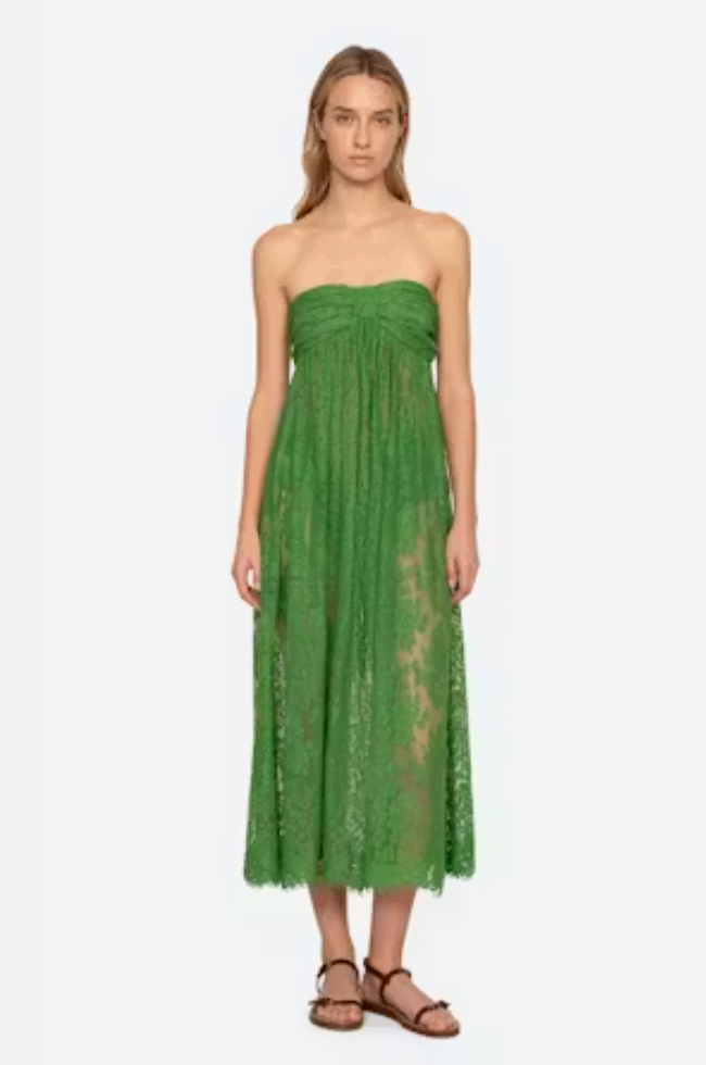Woman wearing a green strapless lace dress on a white background