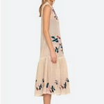 Woman wearing a beige sleeveless dress with floral patterns on a white background
