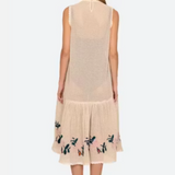 Woman wearing a beige sleeveless dress with floral embroidery on a white background