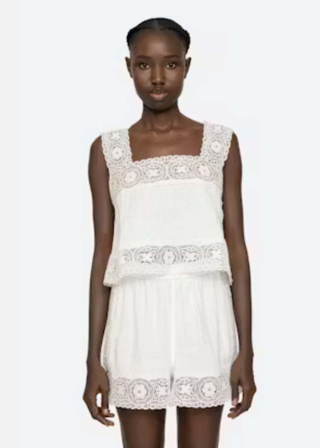 White lace dress worn by a model on a white background