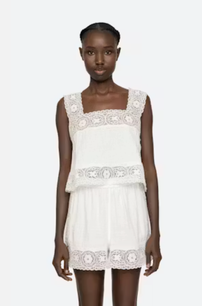 White lace dress worn by a model on a white background
