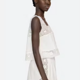 Woman wearing a white lace dress on a white background
