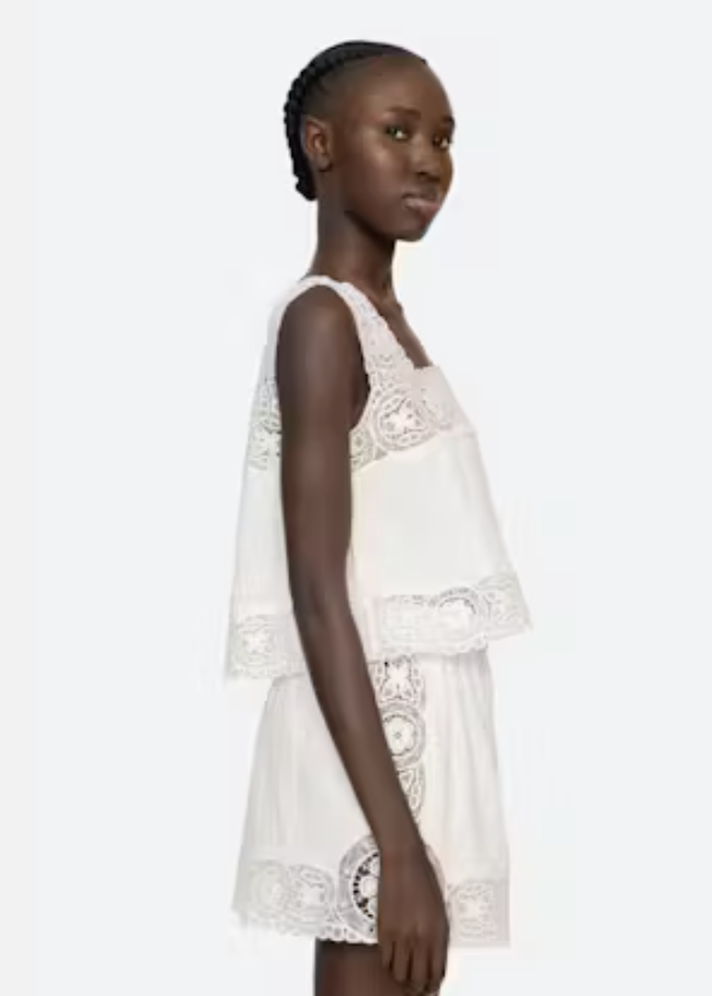 Woman wearing a white lace dress on a white background