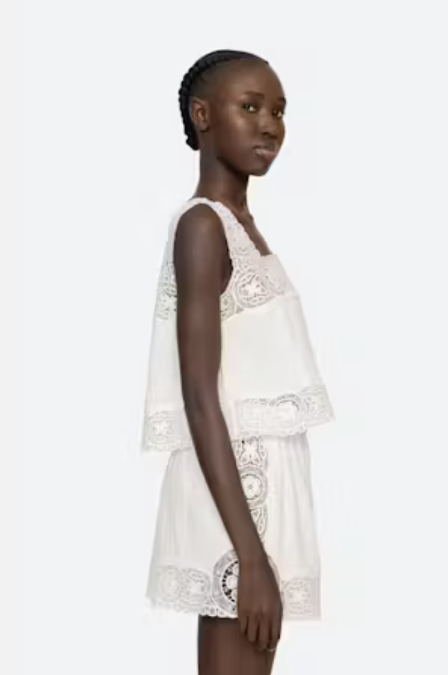 Woman wearing a white lace dress on a white background