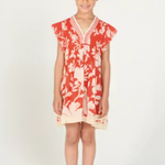 Young girl wearing a red and white floral dress on a white background