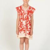 Young girl wearing a red and white floral dress on a white background