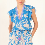 Woman wearing a blue floral romper with a white background