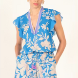 Woman wearing a blue floral romper with a white background