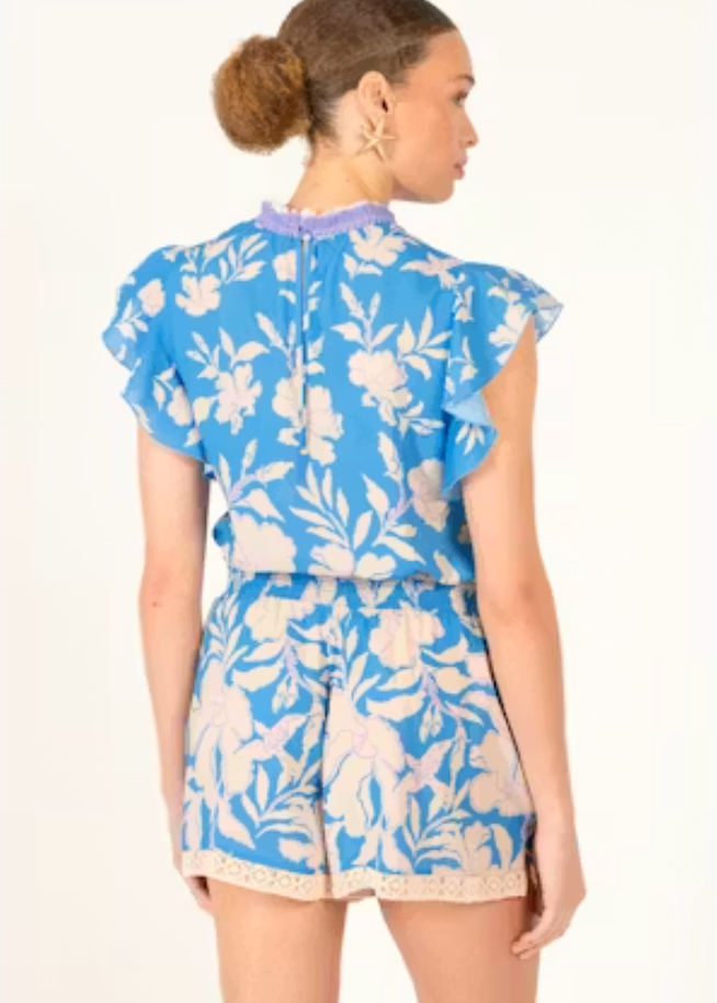 Woman wearing a blue floral outfit on a white background