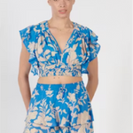 Woman wearing a blue floral two-piece outfit on a white background
