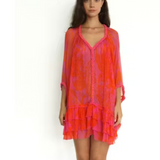 Woman wearing a vibrant orange and pink dress on a white background