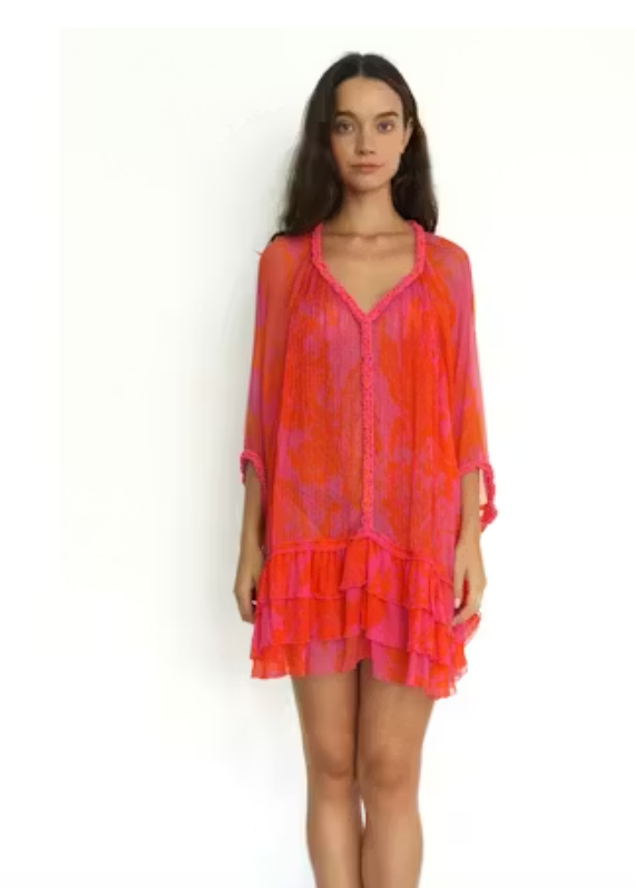 Woman wearing a vibrant orange and pink dress on a white background
