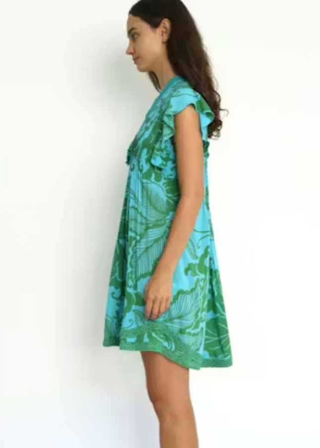 Woman wearing a green and blue patterned dress on a white background