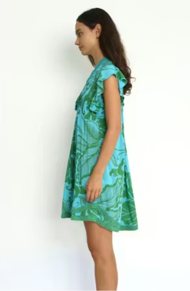 Woman wearing a green and blue patterned dress on a white background