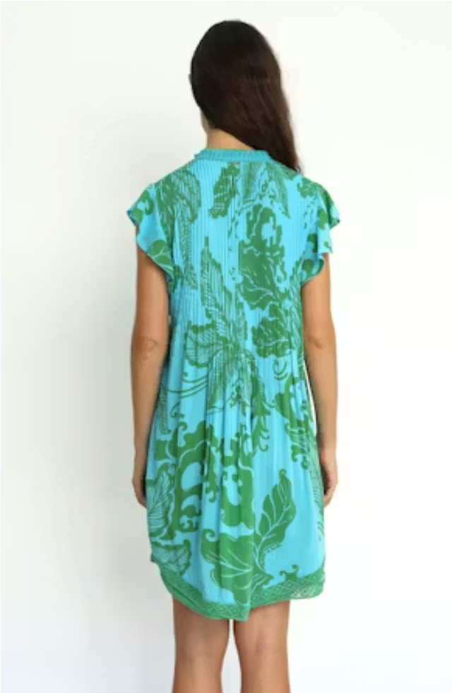 Woman wearing a blue and green patterned dress on a white background