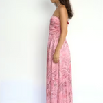 Woman wearing a pink floral dress against a white background