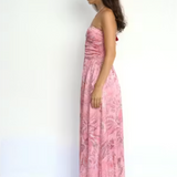 Woman wearing a pink floral dress against a white background