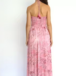 Woman wearing a pink floral dress on a white background