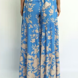 Blue floral pants worn by a person on a white background
