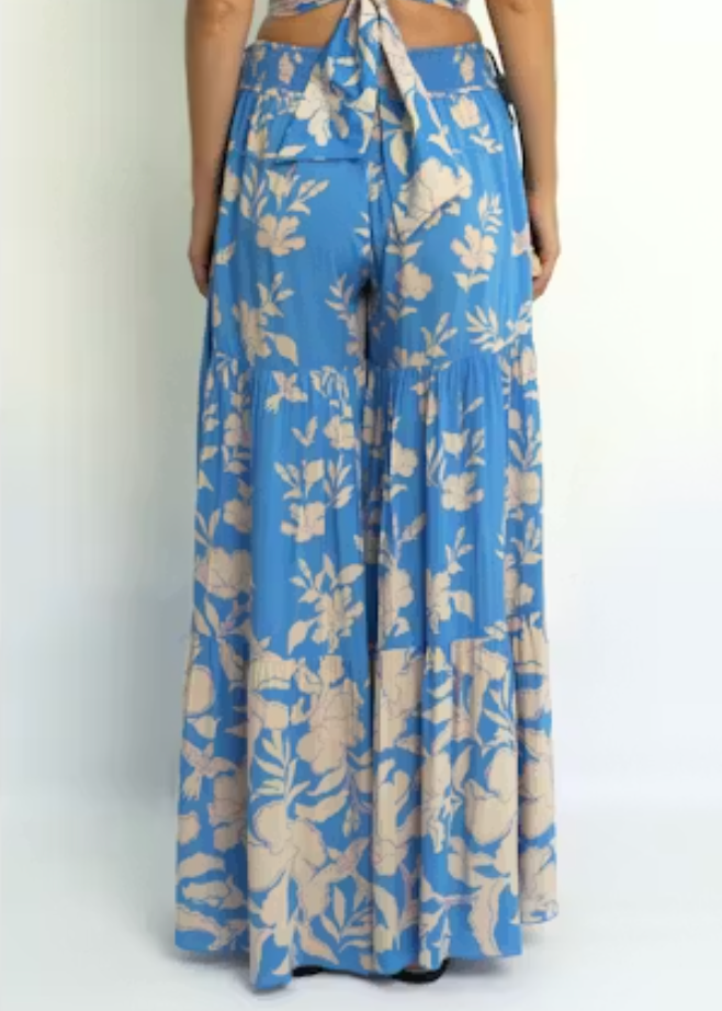 Blue floral pants worn by a person on a white background