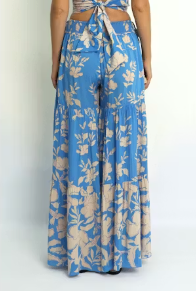 Blue floral pants worn by a person on a white background
