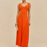 Woman wearing an orange dress against a beige background