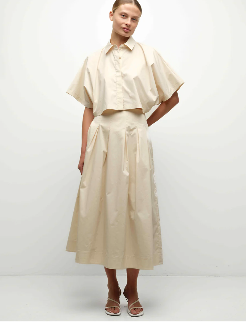 Woman wearing a beige outfit with a white background