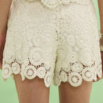 Lace shorts on a person against a green background