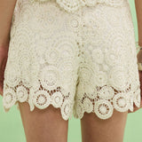 Lace shorts on a person against a green background