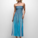 Woman wearing a blue striped strapless dress on a white background