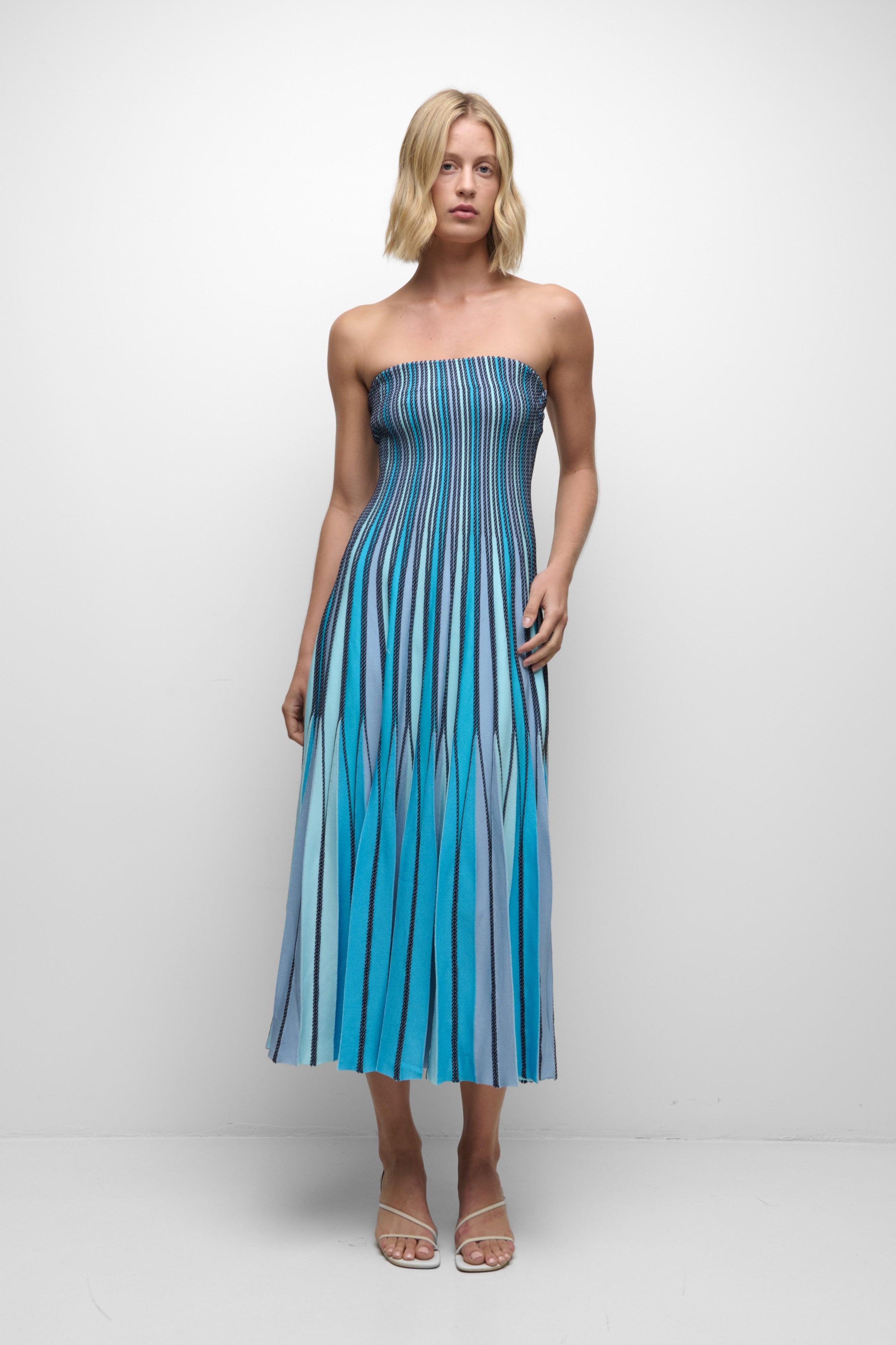 Woman wearing a blue striped strapless dress on a white background