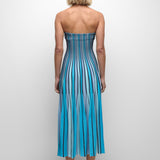 Woman wearing a strapless blue and white striped dress on a plain background