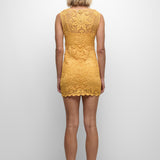 Person wearing a yellow lace dress on a white background
