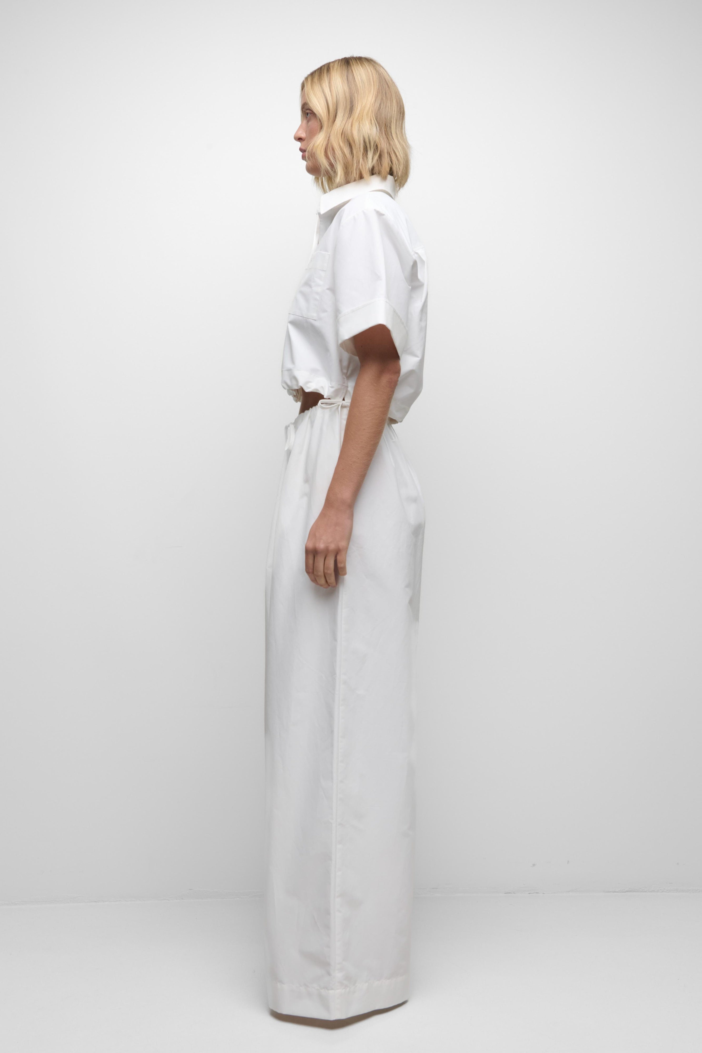 Person wearing a white outfit on a plain background