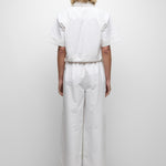 Person wearing a white outfit on a plain background