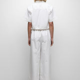 Person wearing a white outfit on a plain background