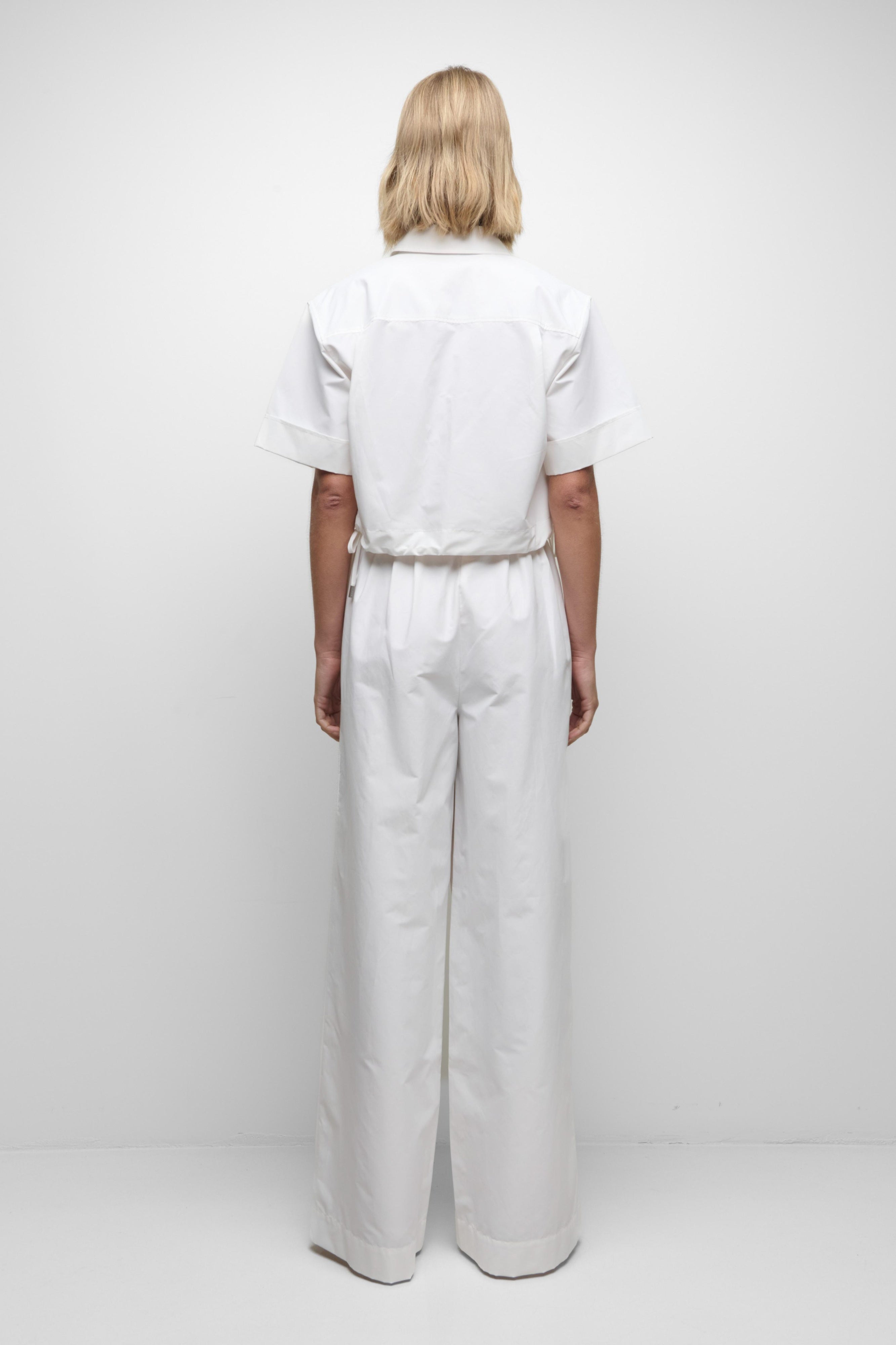 Person wearing a white outfit on a plain background