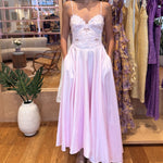 Woman wearing a white lace dress in a store setting