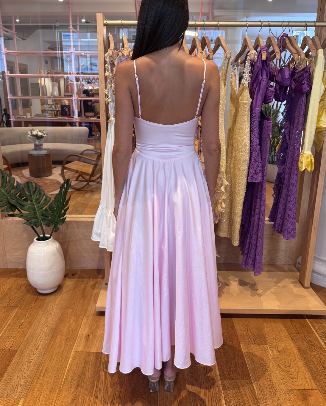Woman wearing a light pink dress in a clothing store.